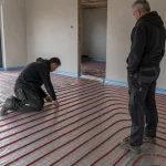 Draadstaalmatten leggen voor vloerverwarming met buizen vastgebonden op een kale vloer